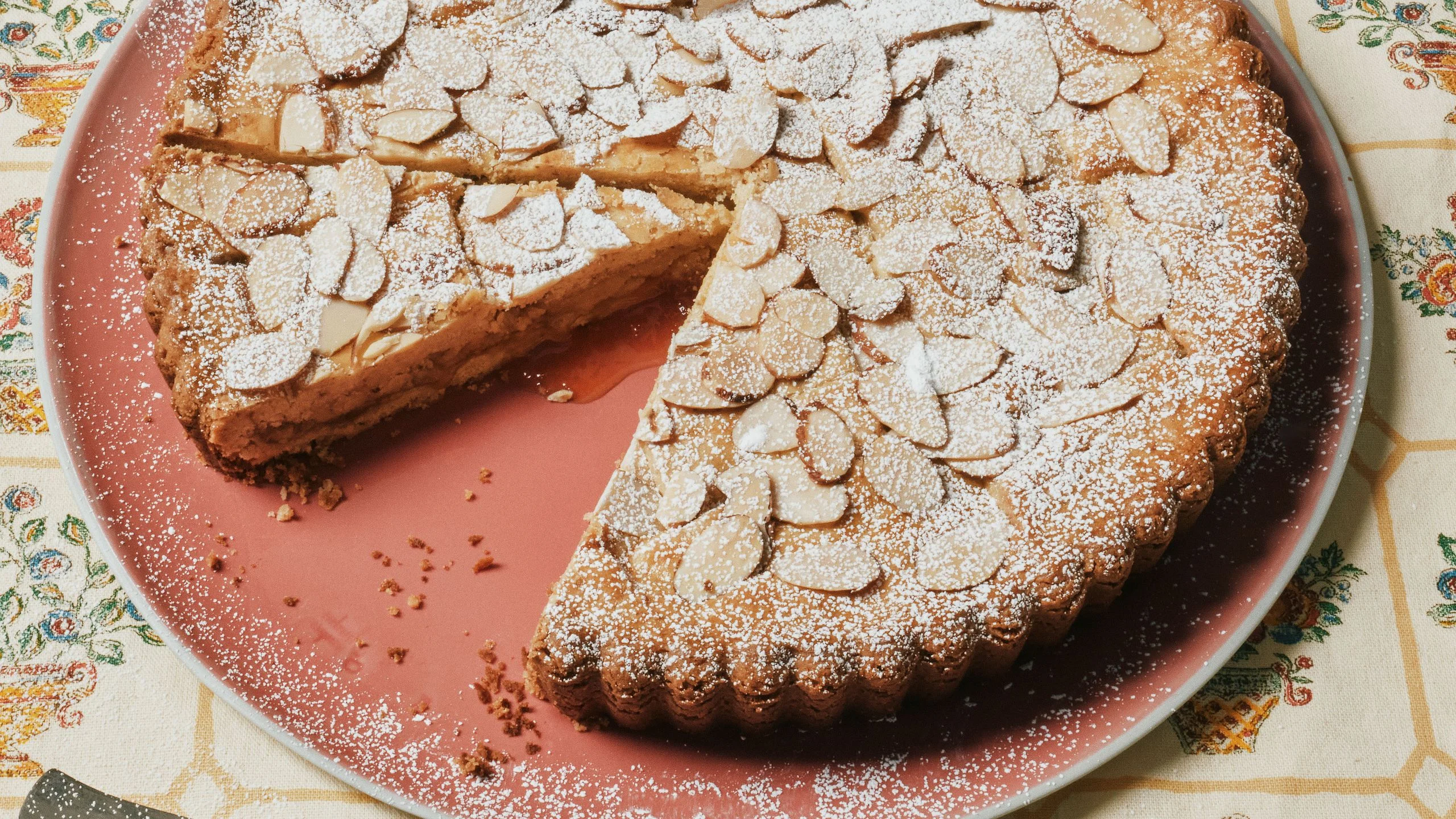An almond apricot crostata sliced on a cake plate.