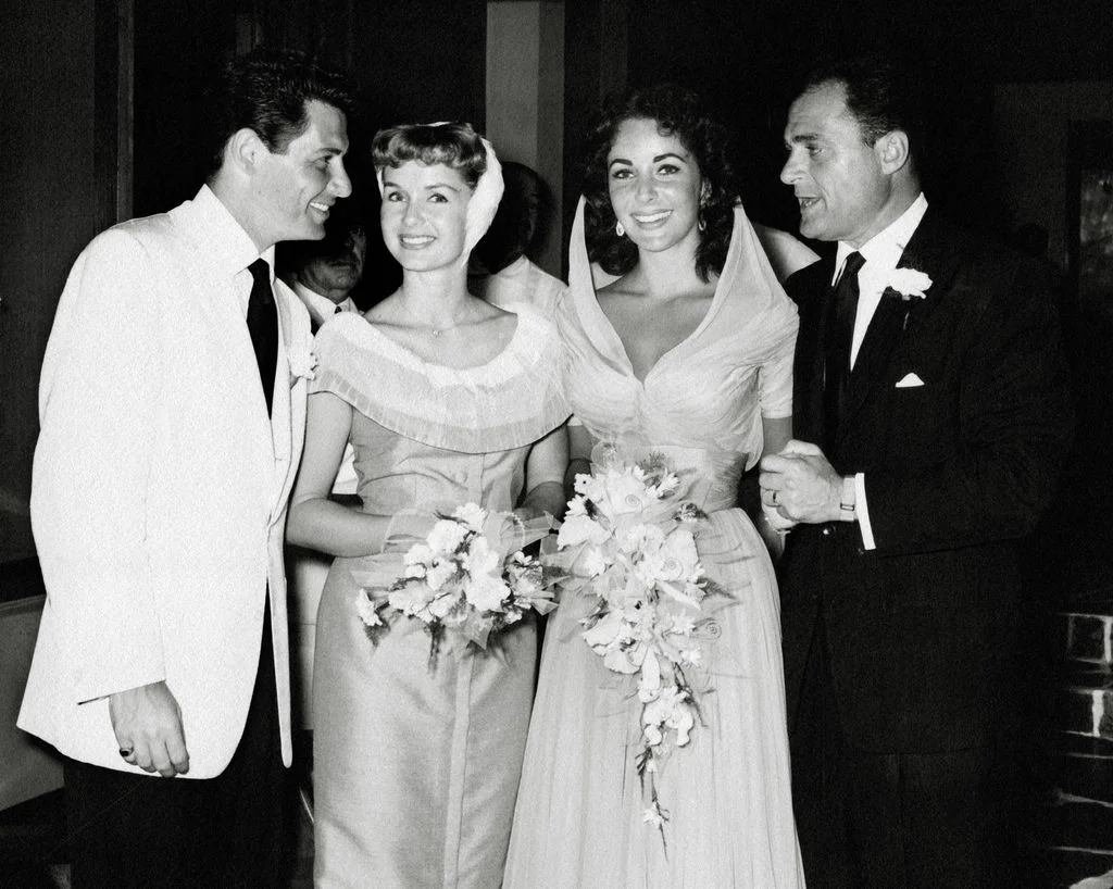 Image may contain Clothing Apparel Suit Coat Overcoat Elizabeth Taylor Debbie Reynolds Tie and Accessories