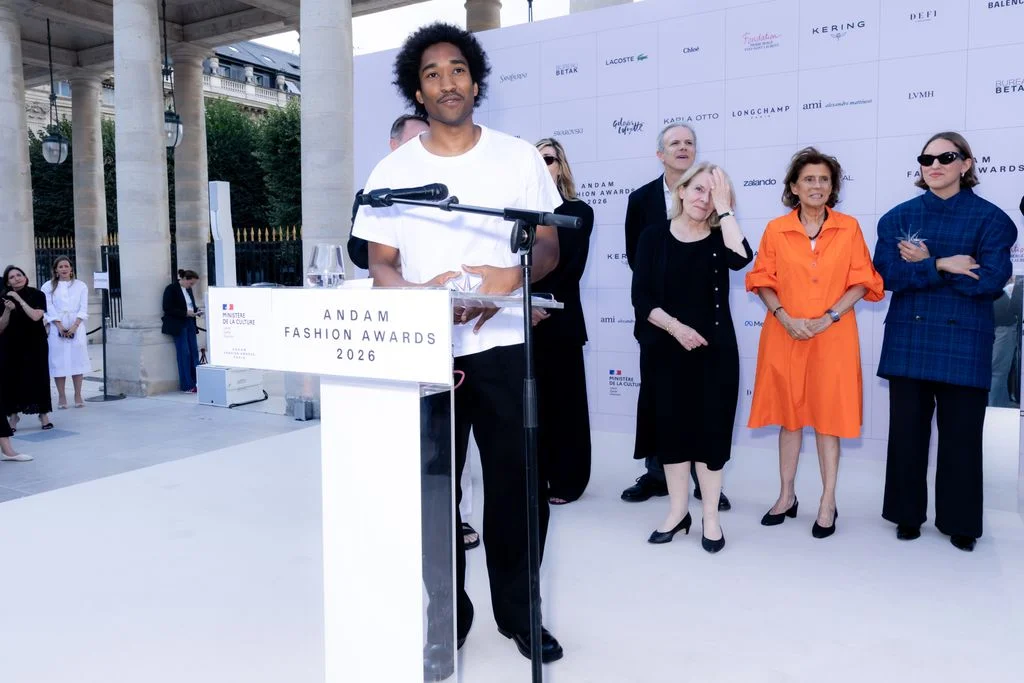 Image may contain Crowd Person Adult Audience Clothing Footwear High Heel Shoe Speech Podium and Electrical Device