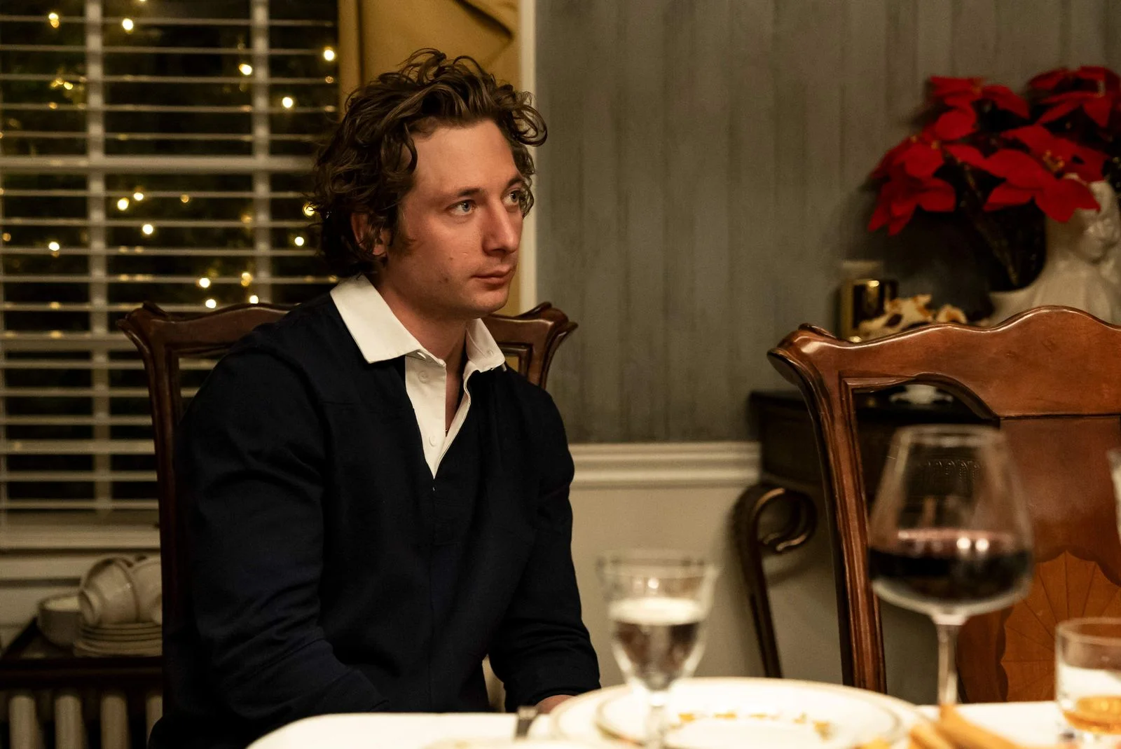 Image may contain Jeremy Allen White Adult Person Face Head Photography Portrait Dining Table Furniture and Table
