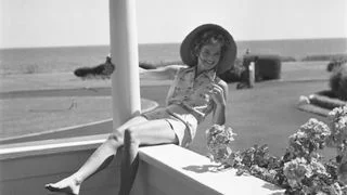 Image may contain Jacqueline Kennedy Onassis Clothing Hat Plant Potted Plant Sun Hat Adult Person Shorts and Face