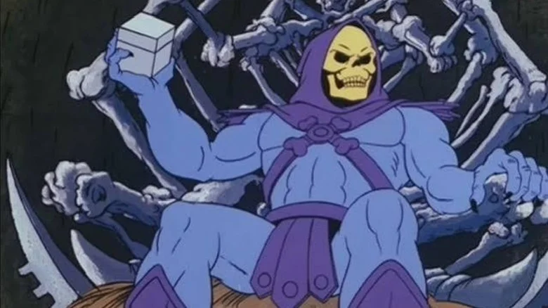 Skeletor sitting on his throne, holding a box in one hand in He-Man and the Masters of the Universe (1983)