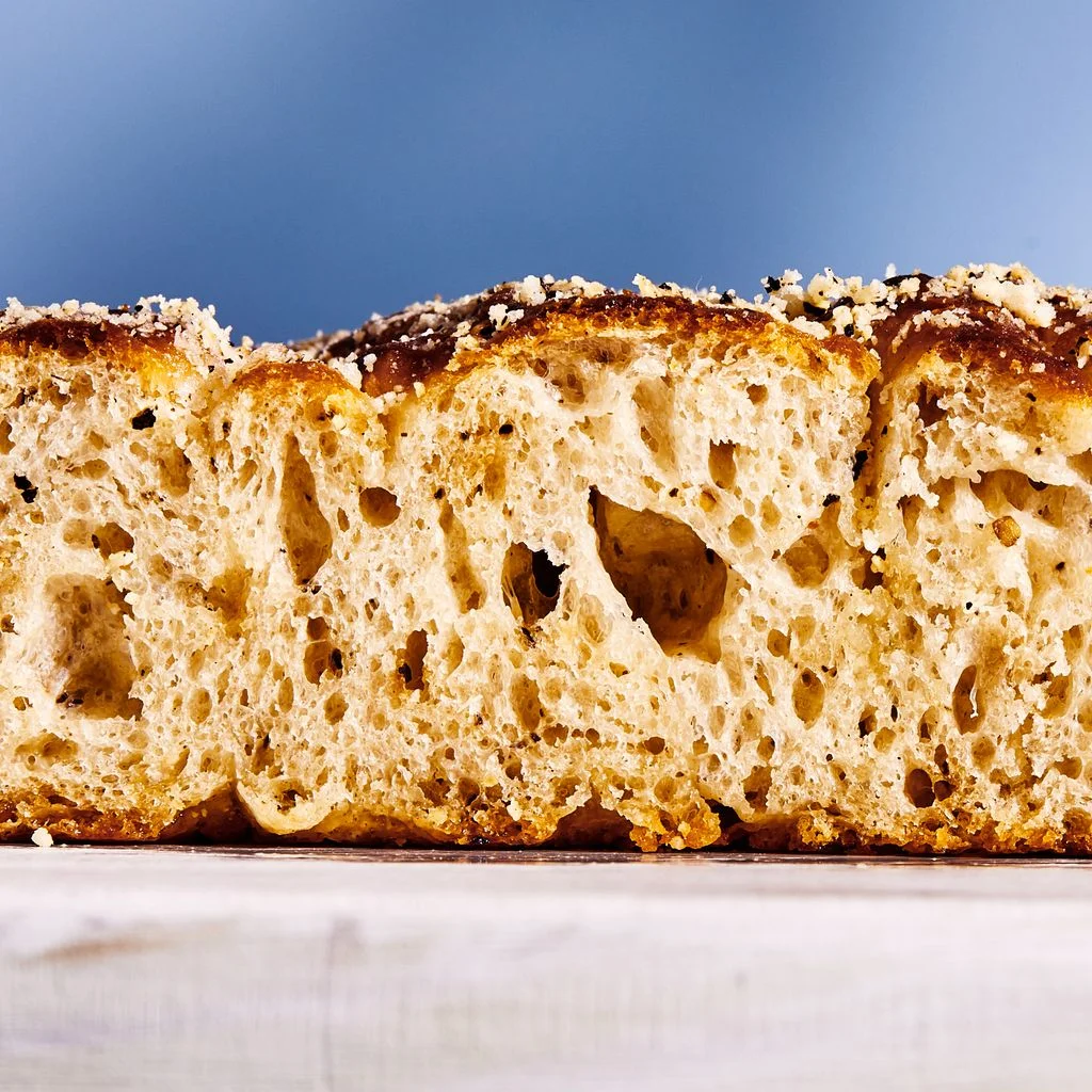 Crosssection of cacio e pepe focaccia topped with cheese