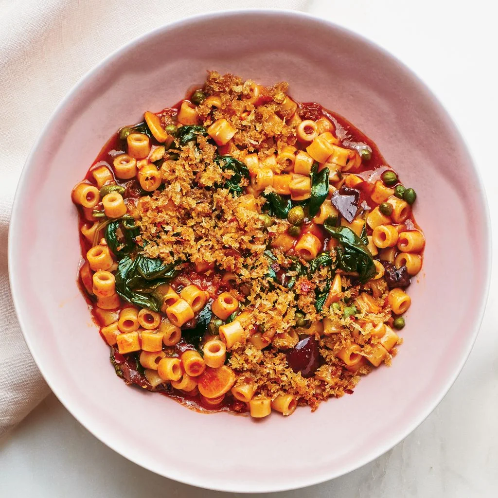 Two bowls of pasta puttanesca on a white table