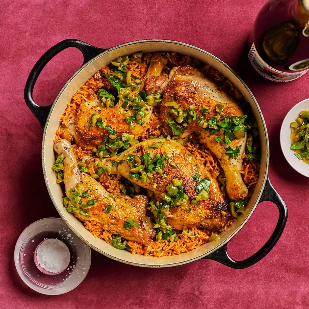 Chicken and Rice With Olive Gremolata in a dutch oven on a red fabric surface