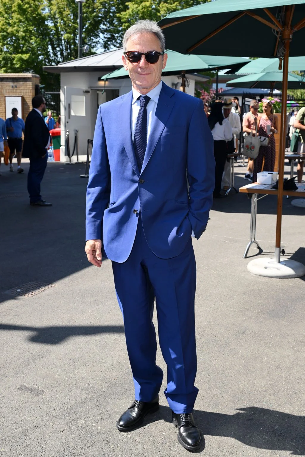 Image may contain Jason Isaacs Clothing Formal Wear Suit Person Standing Adult Accessories Sunglasses and Bag