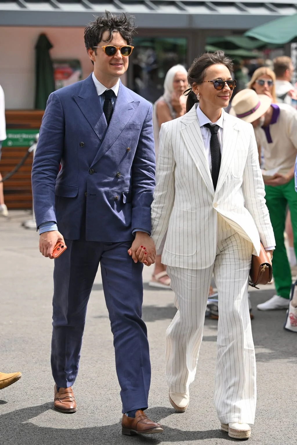 Image may contain Ezra Koenig Rashida Jones Clothing Formal Wear Suit Body Part Hand Person Blazer Coat and Jacket