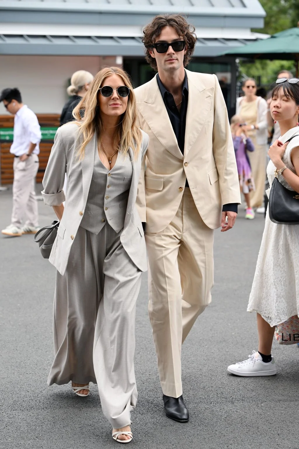 Image may contain Sienna Miller Eugene Sims Clothing Formal Wear Suit Blazer Coat Jacket Person Walking and Adult