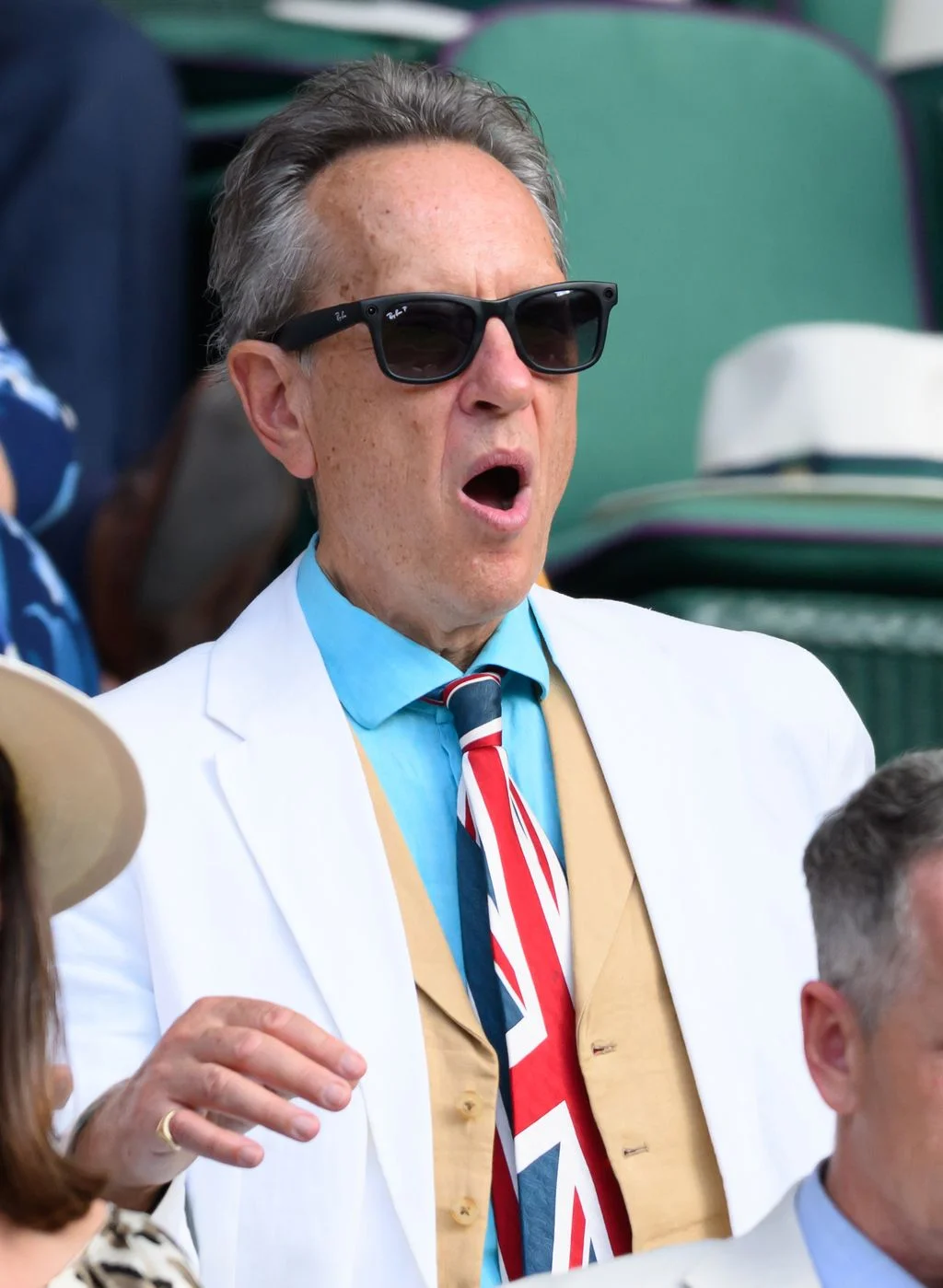 Image may contain Richard E. Grant Head Person Face Yawning Formal Wear Accessories Tie Adult Sunglasses and Angry
