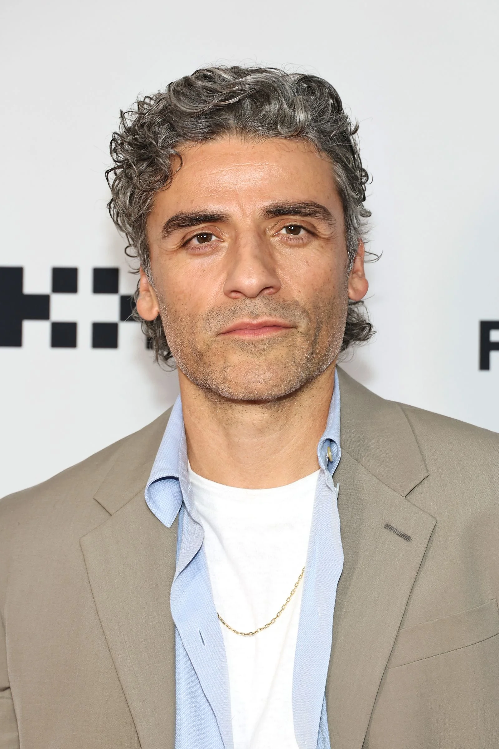 Image may contain Oscar Isaac Body Part Face Head Neck Person Blonde Hair Adult Clothing Coat and Accessories