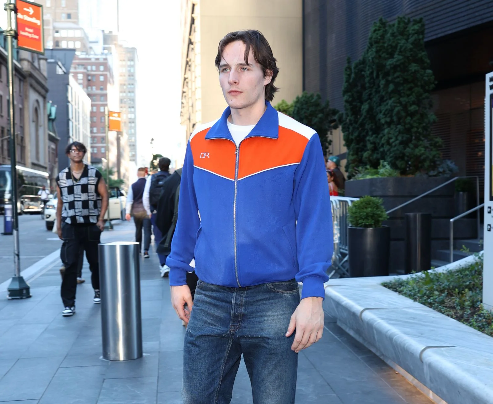 Image may contain Clothing Coat Jacket Pants Sleeve Adult Person Standing Jeans Shirt Face Head and Long Sleeve