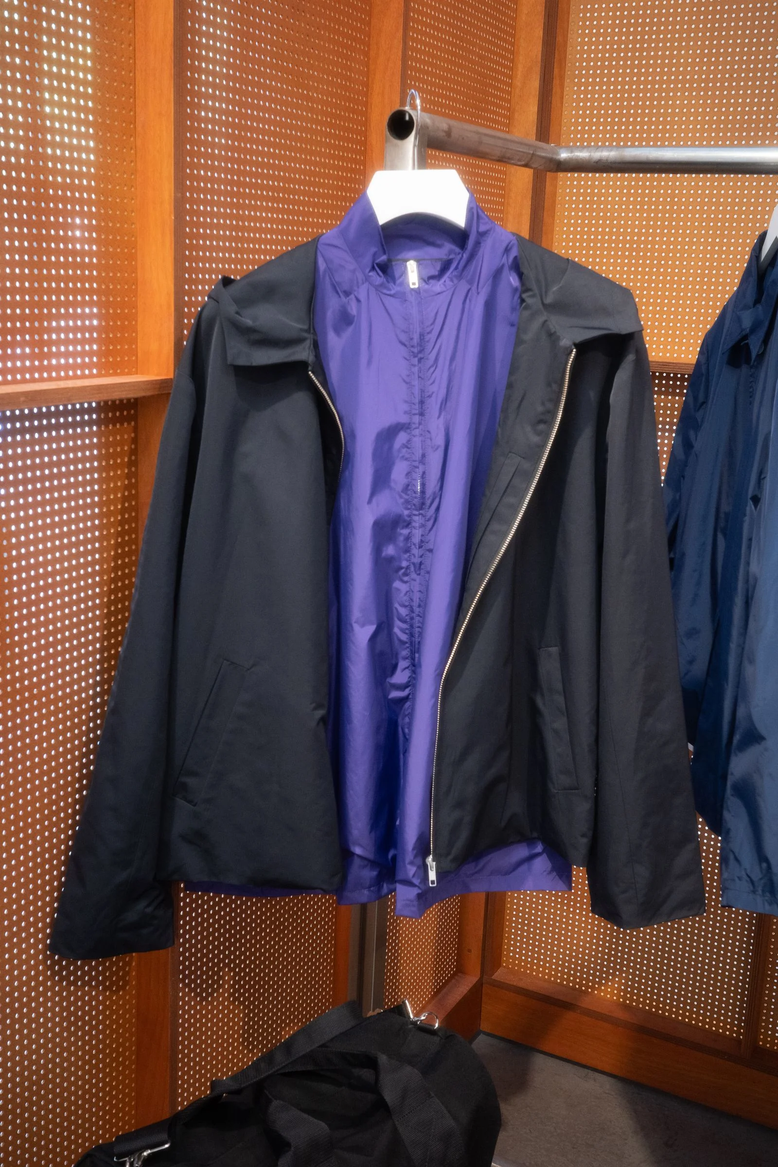 A purple windbreaker with a black jacket over it
