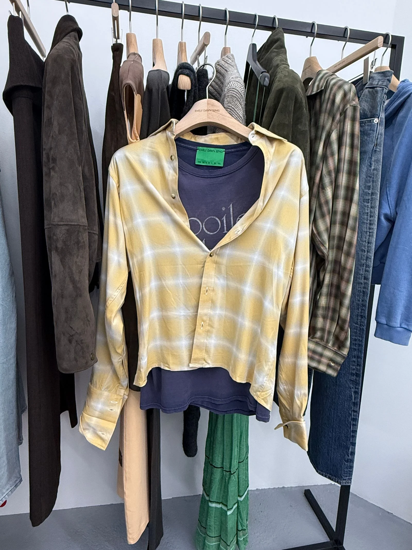 A black tshirt with a checkered yellow buttonup styled over it