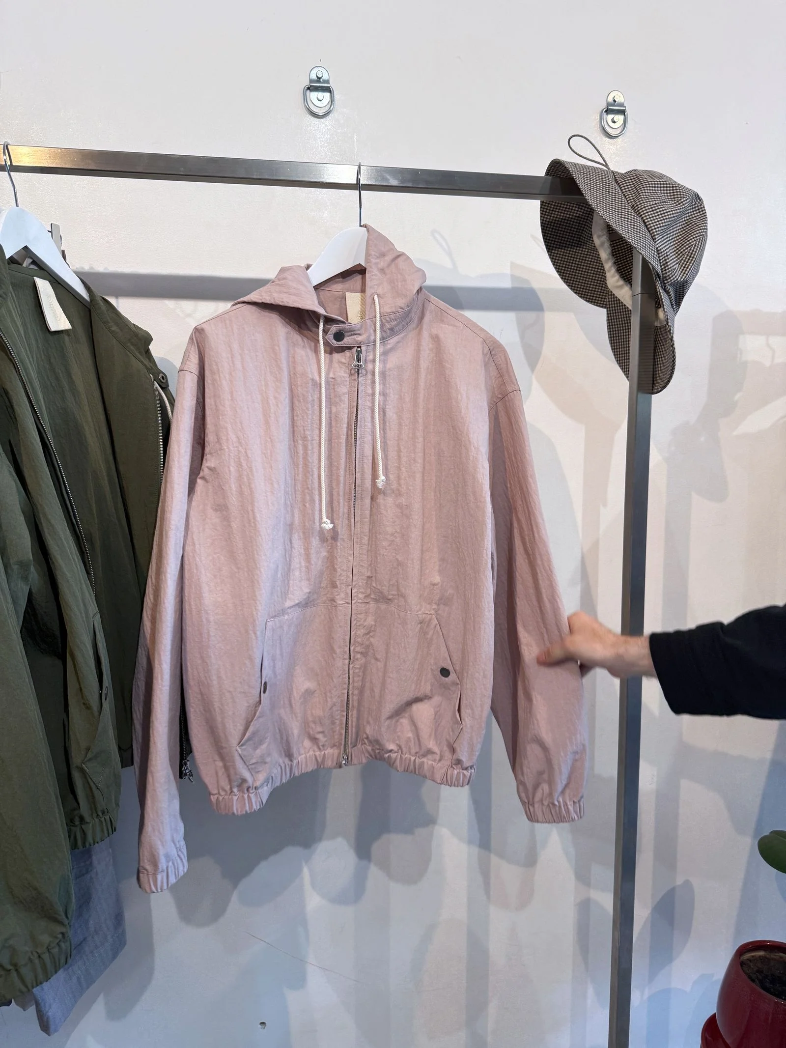 A pink hoodie on a hanger