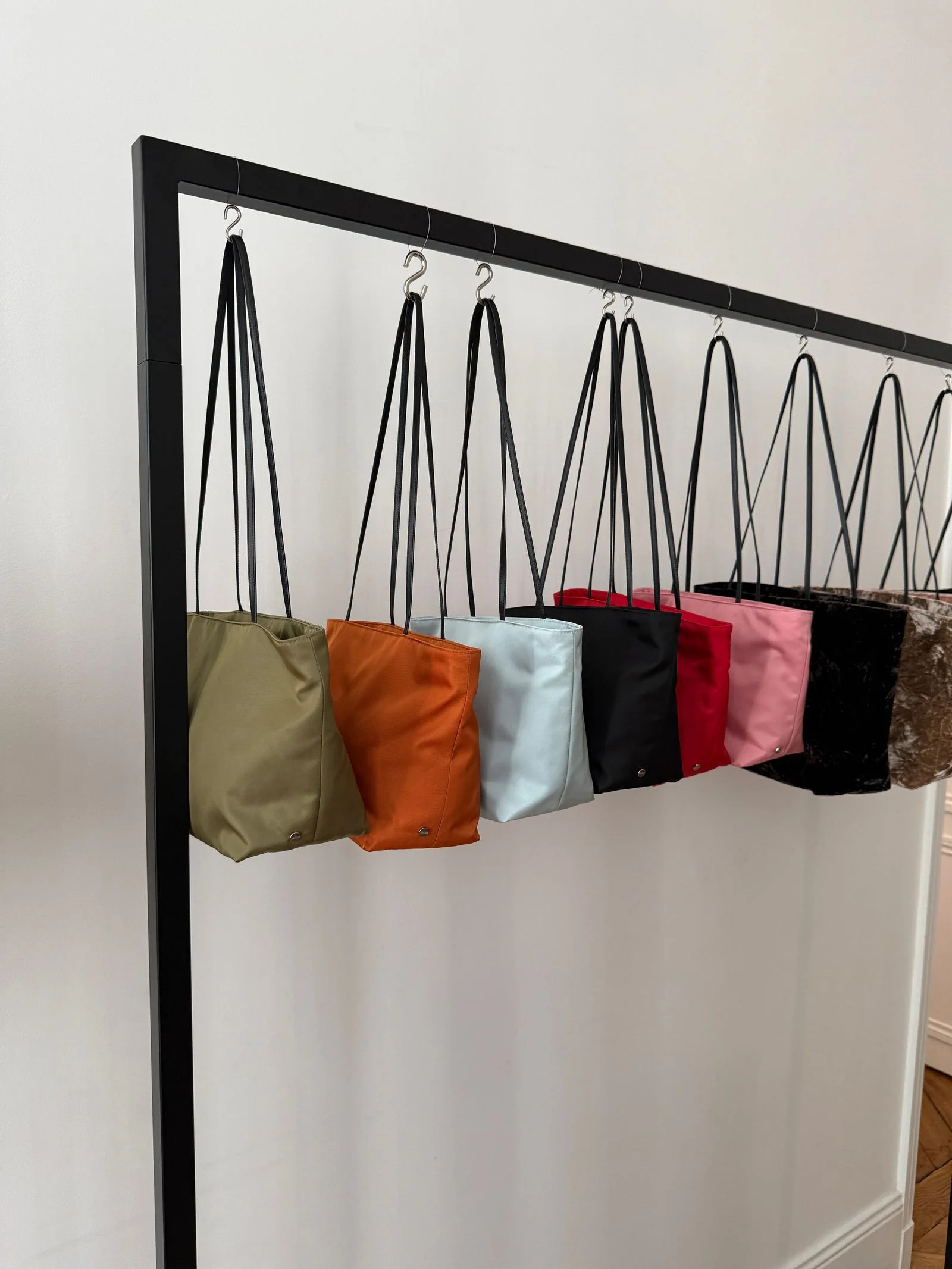 A rack with a series of colorful tote bags