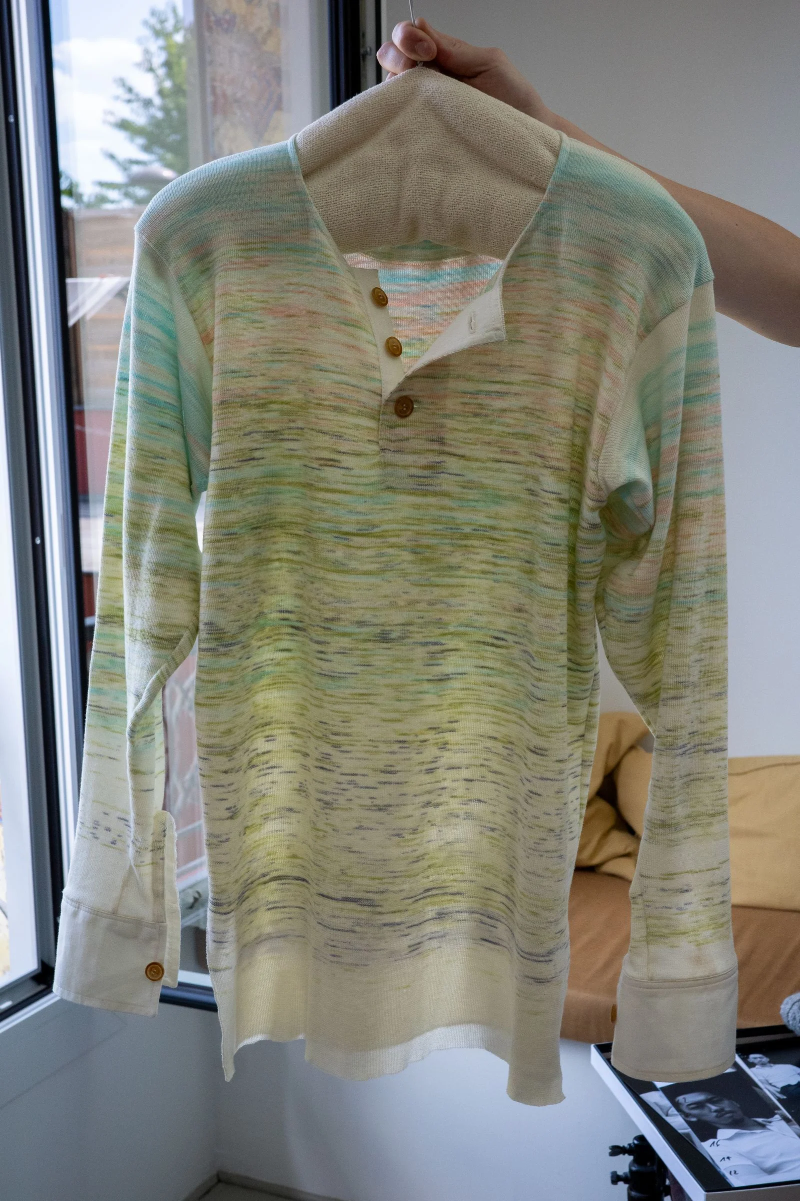 A green white and blue knit blouse