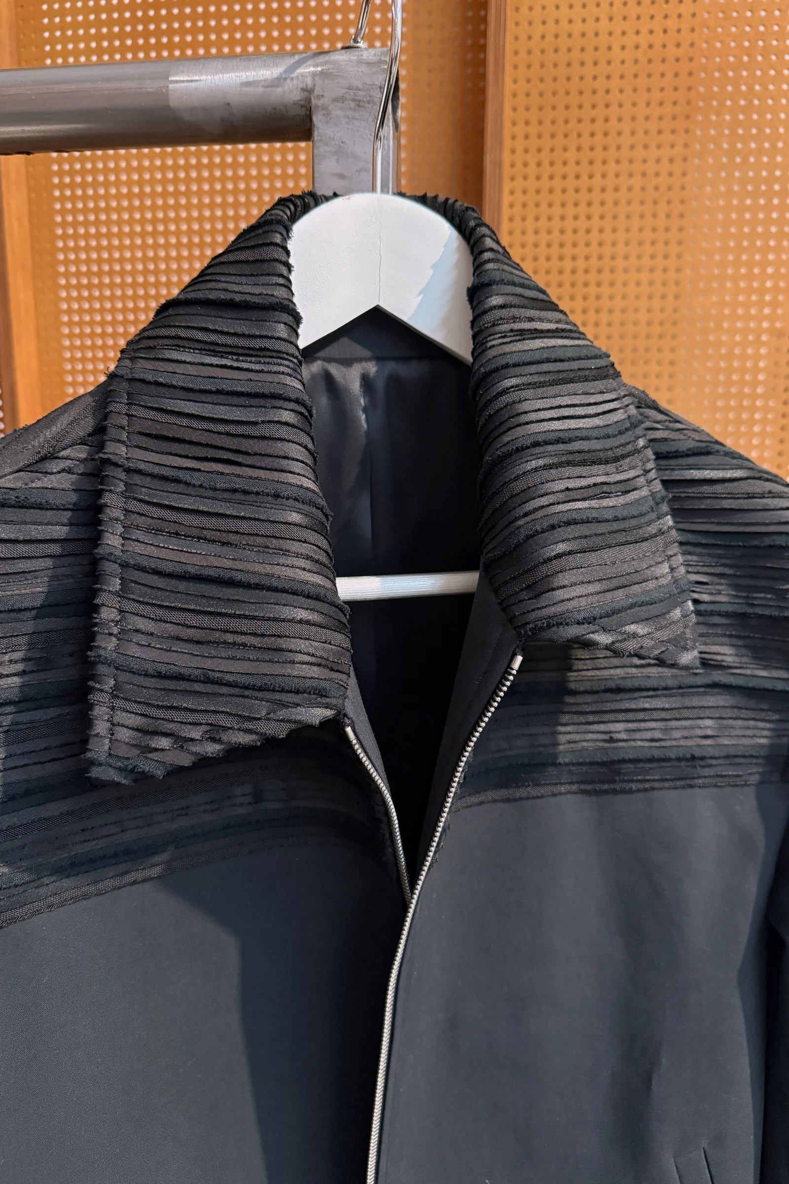 A closeup of the same black jacket with the intricately designed collar