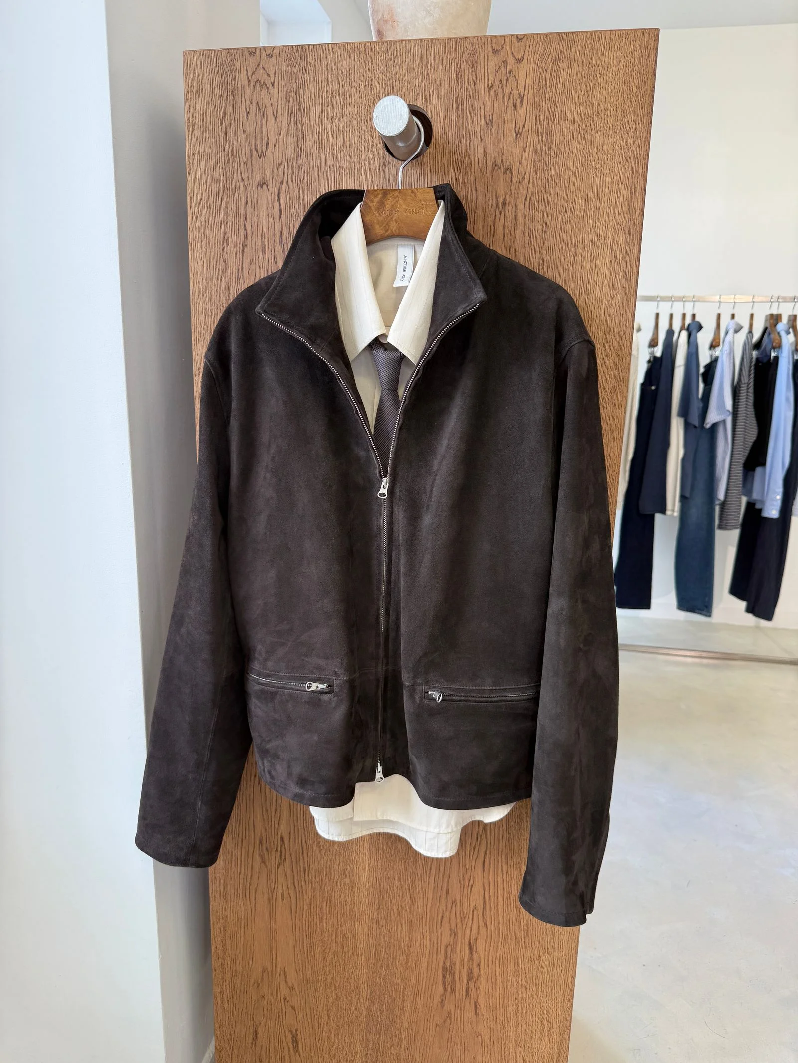 A brown jacket styled over a white buttonup