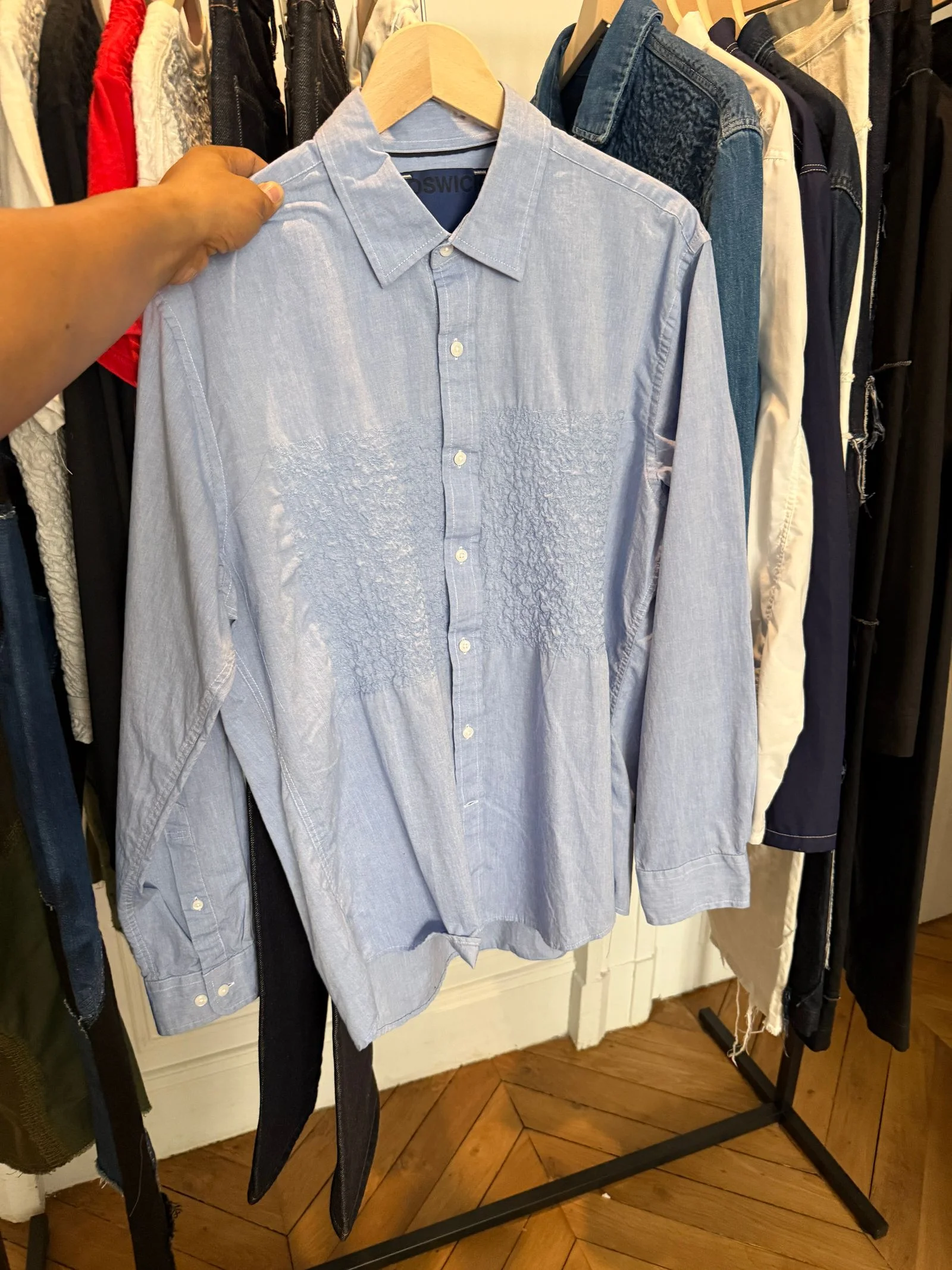 A blue buttonup whose breast is decorated with a crinkled texture
