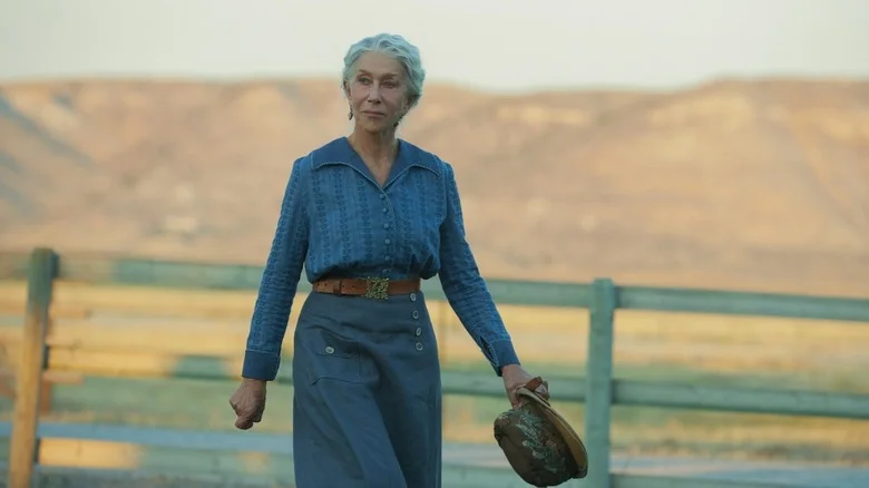 Cara Dutton (Helen Mirren) walks through the ranch holding a hat in 1923