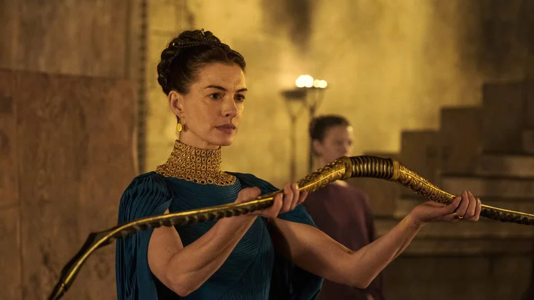 Anne Hathaway as Penelope holding a bow in The Odyssey