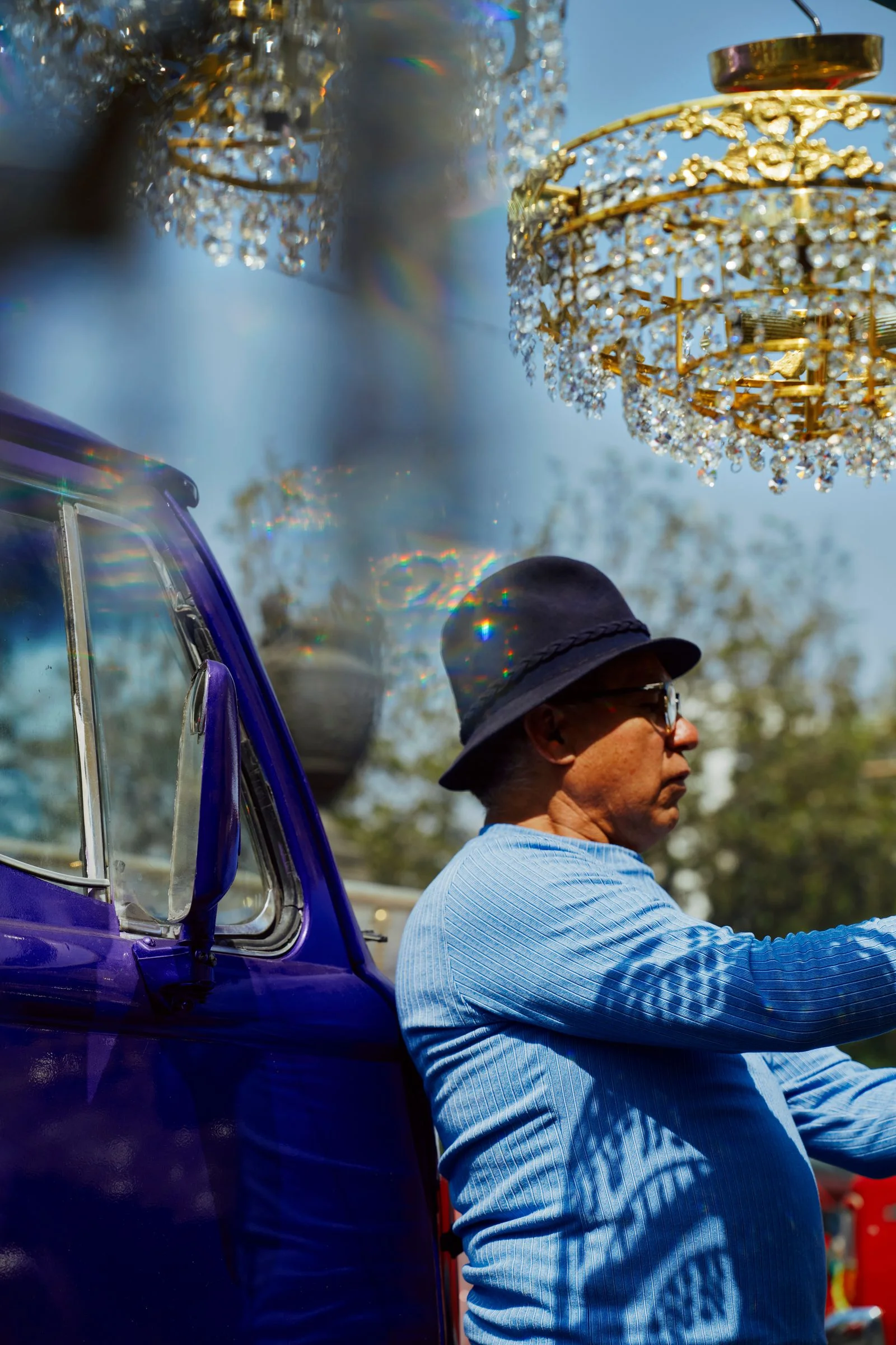 Image may contain Chandelier Lamp Adult Person Clothing Hat Car Transportation Vehicle Truck and Head