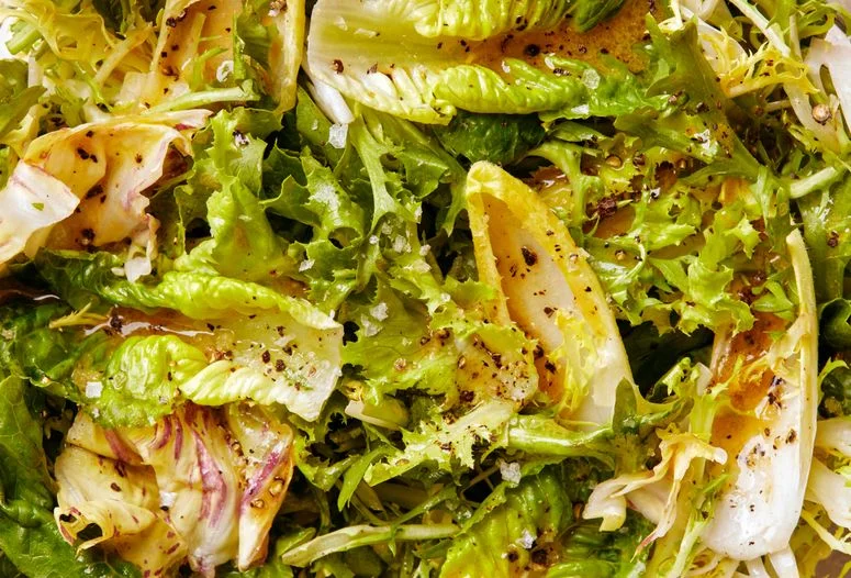A macro shot of vinaigrette on lettuce