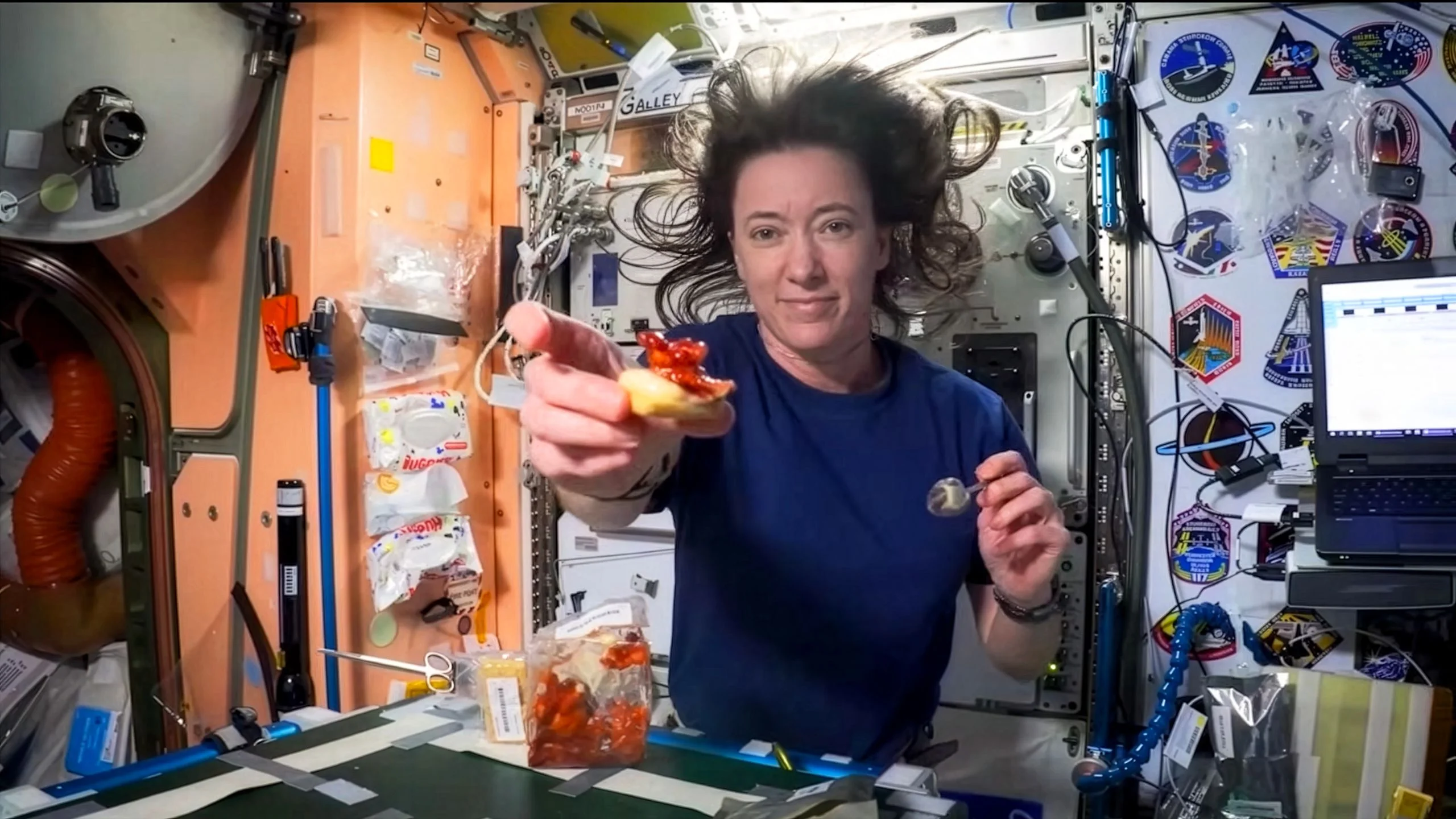 An astronaut showing space food to the camera while in shuttle