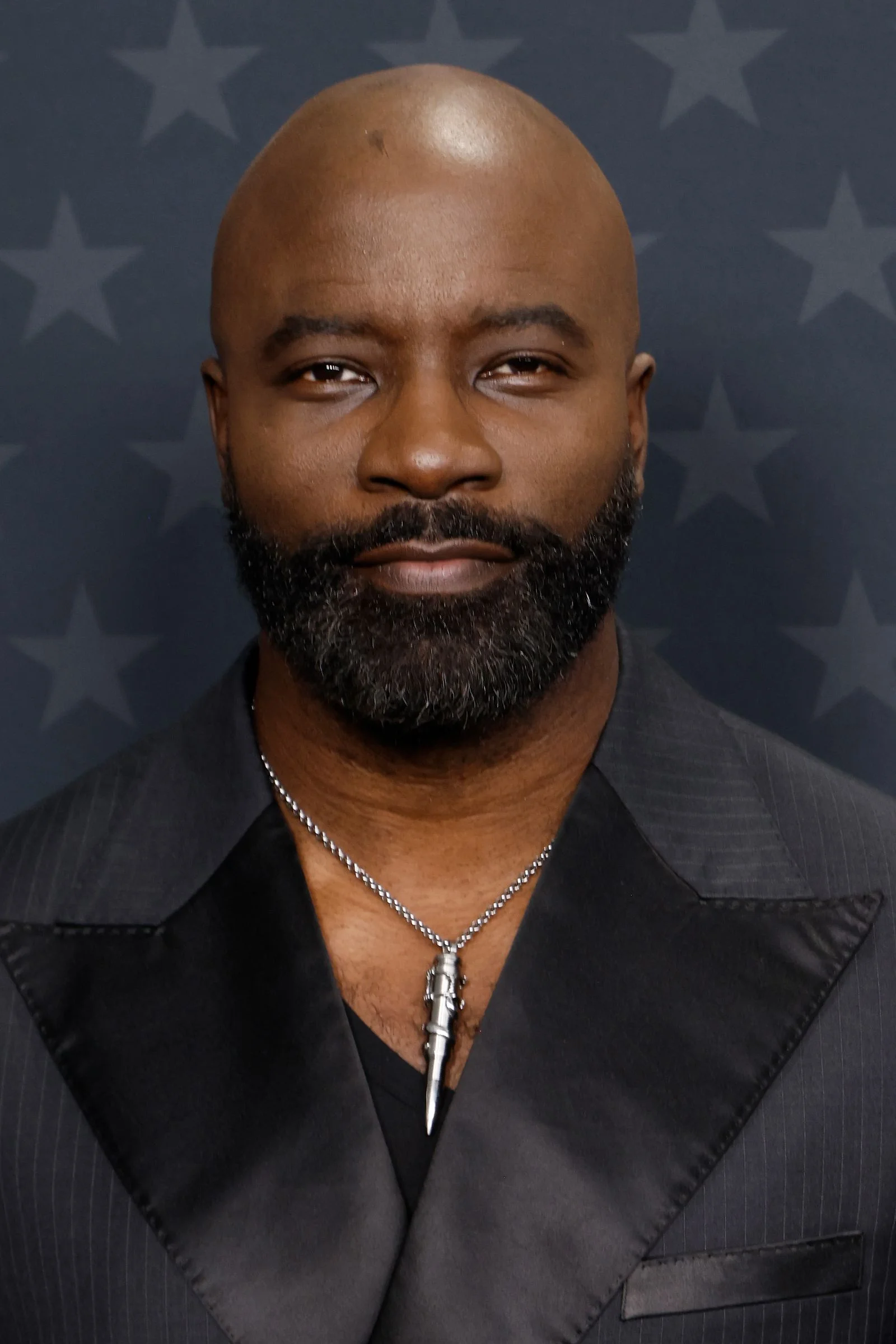 Image may contain Mike Colter Head Person Face Accessories Jewelry Necklace Body Part Neck Adult and Clothing