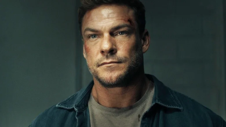 Alan Ritchson's Jack Reacher sits in an interrogation room in Reacher