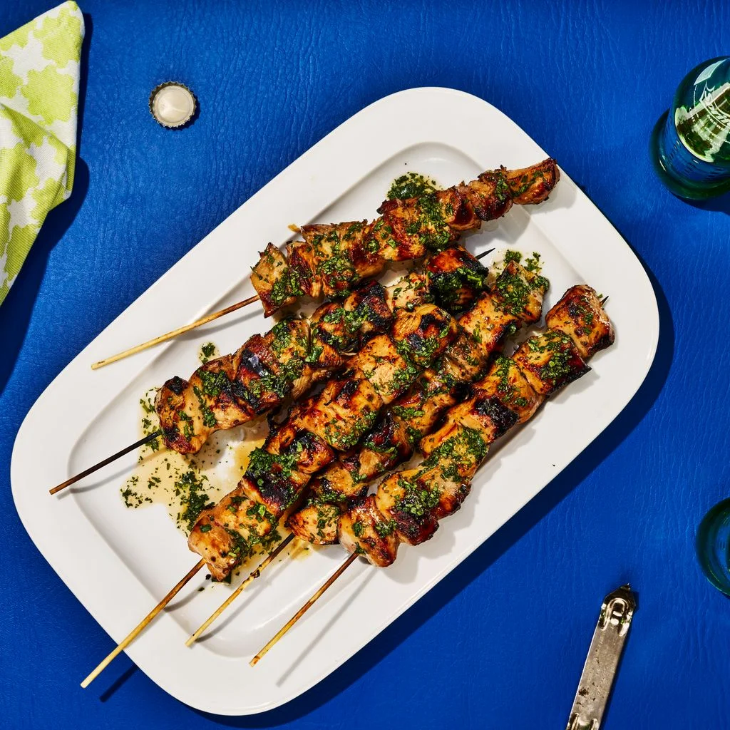 Charred SpriteGrilled Chicken Skewers served on a platter with herb sauce.