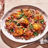 Olive-Brine-Marinated Chicken With Date Relish in white dish with spoon on tan background