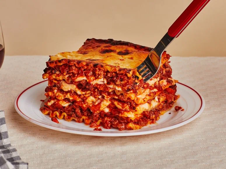 A slice of lasagna on a white plate