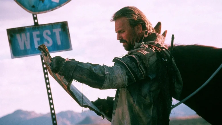 Kevin Costner as the Postman looking at a map in The Postman