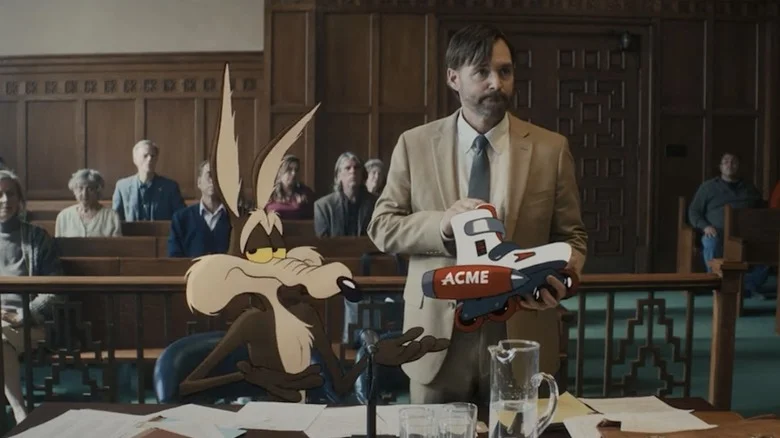 Wile E. Coyote sitting next to Will Forte as Kevin Avery in a courtroom in Coyote vs. Acme