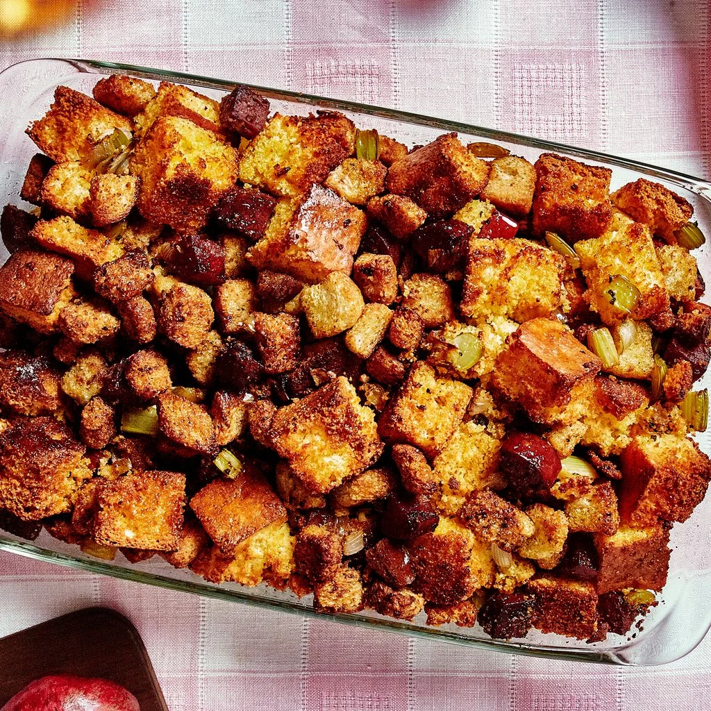 Overhead view of cornbread dressing with cubes of cornbread and chopped salami.