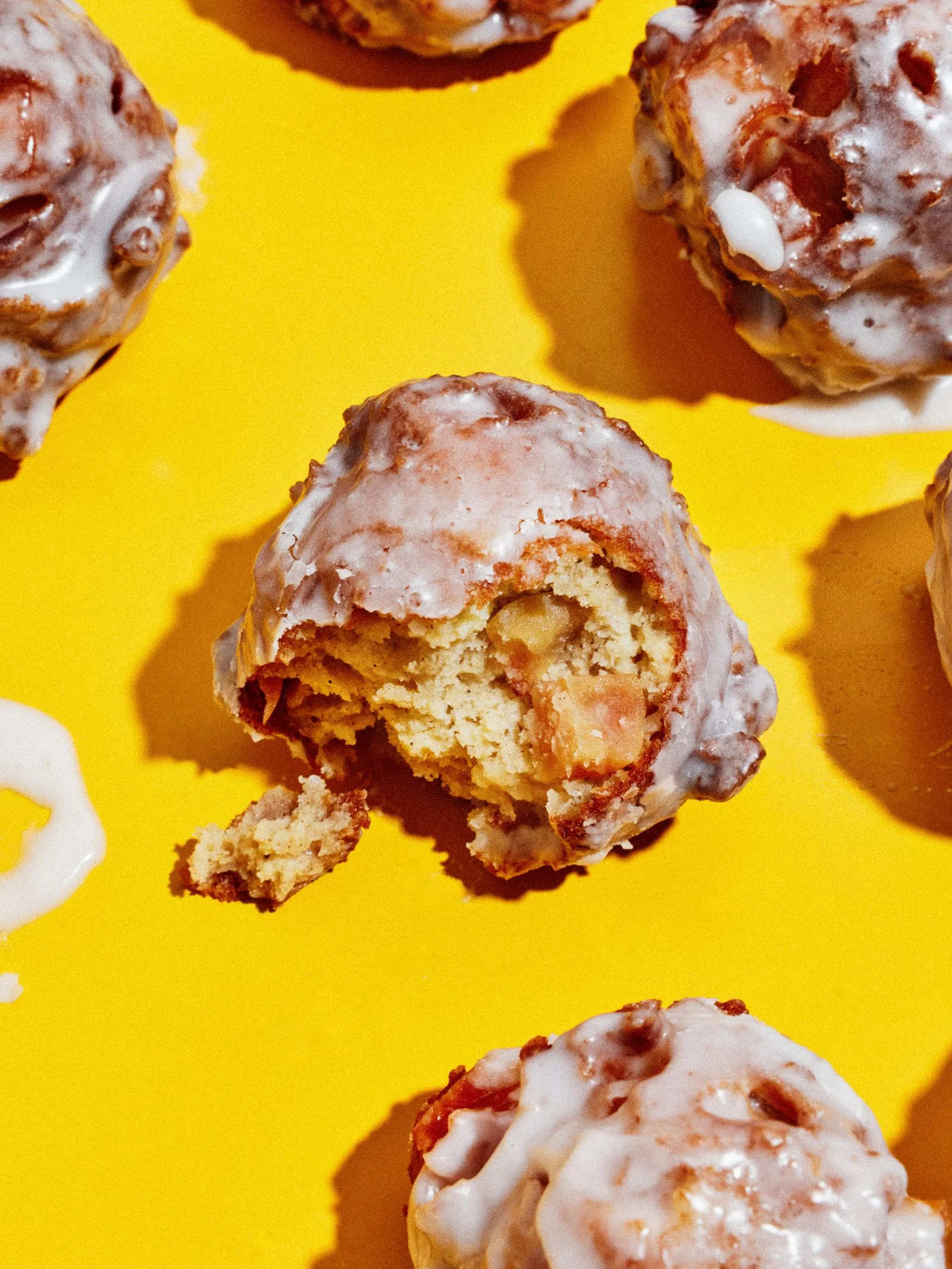 Freshly fried Apple Pie Donuts on a yellow background