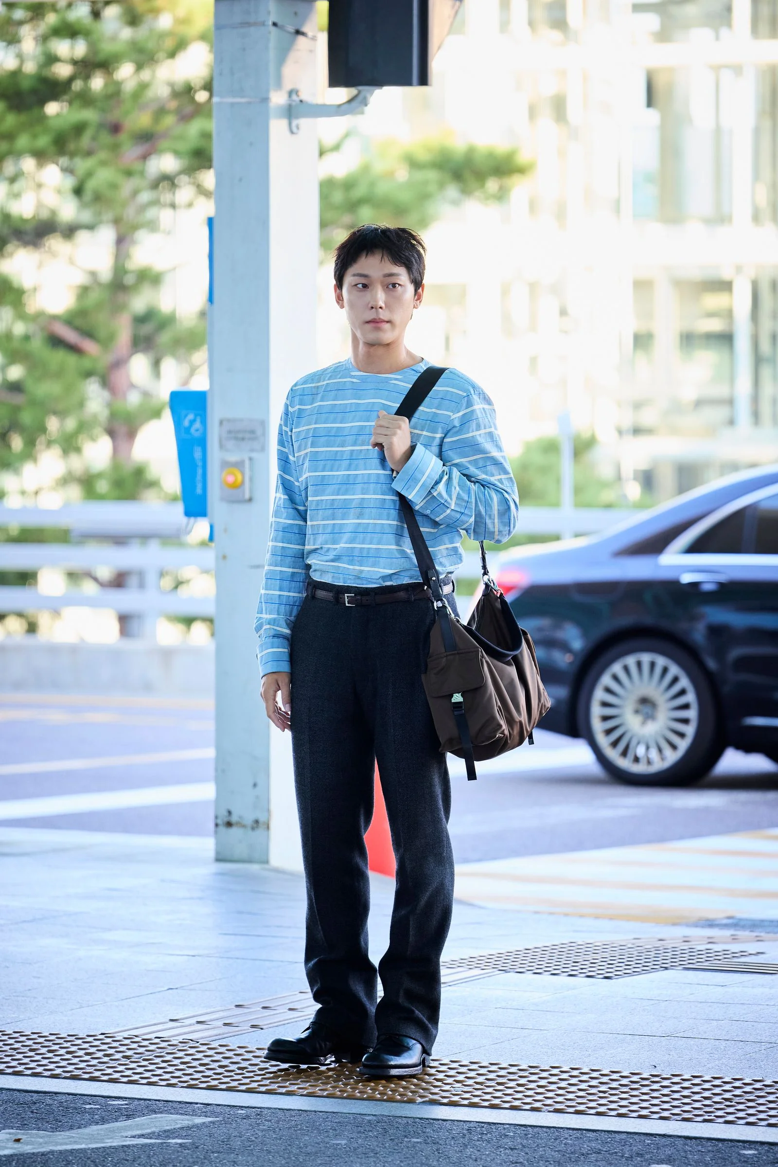 Image may contain Clothing Pants Pedestrian Person Standing Teen Car Transportation and Vehicle