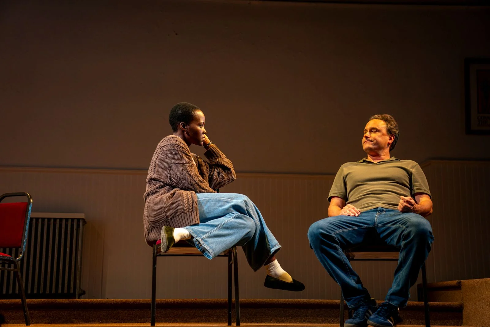 Image may contain Lupita Nyong'o Person Sitting Adult Head Face Clothing Pants Jeans Footwear and Shoe