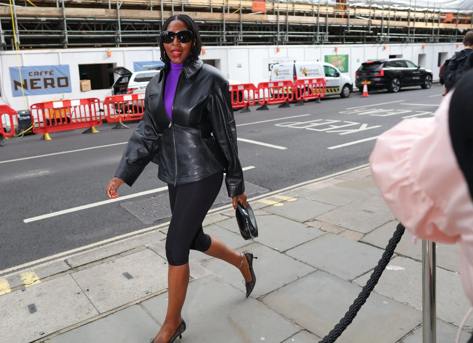 Image may contain Clothing Coat Jacket Footwear Shoe Pedestrian Person High Heel Car Transportation and Vehicle
