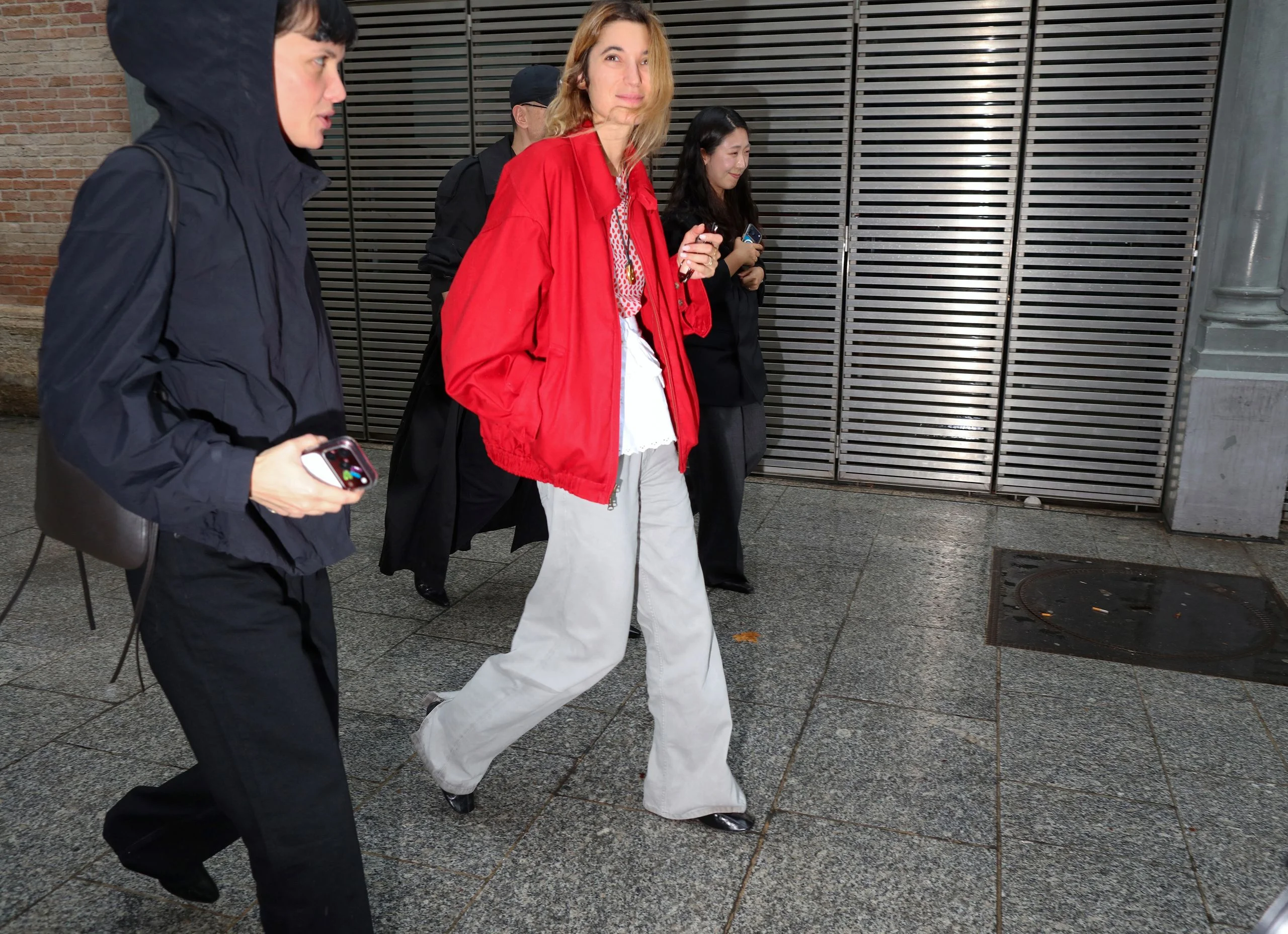 Image may contain Clothing Coat Jacket Blazer Pants Adult Person Walking Footwear Shoe Blouse and Formal Wear