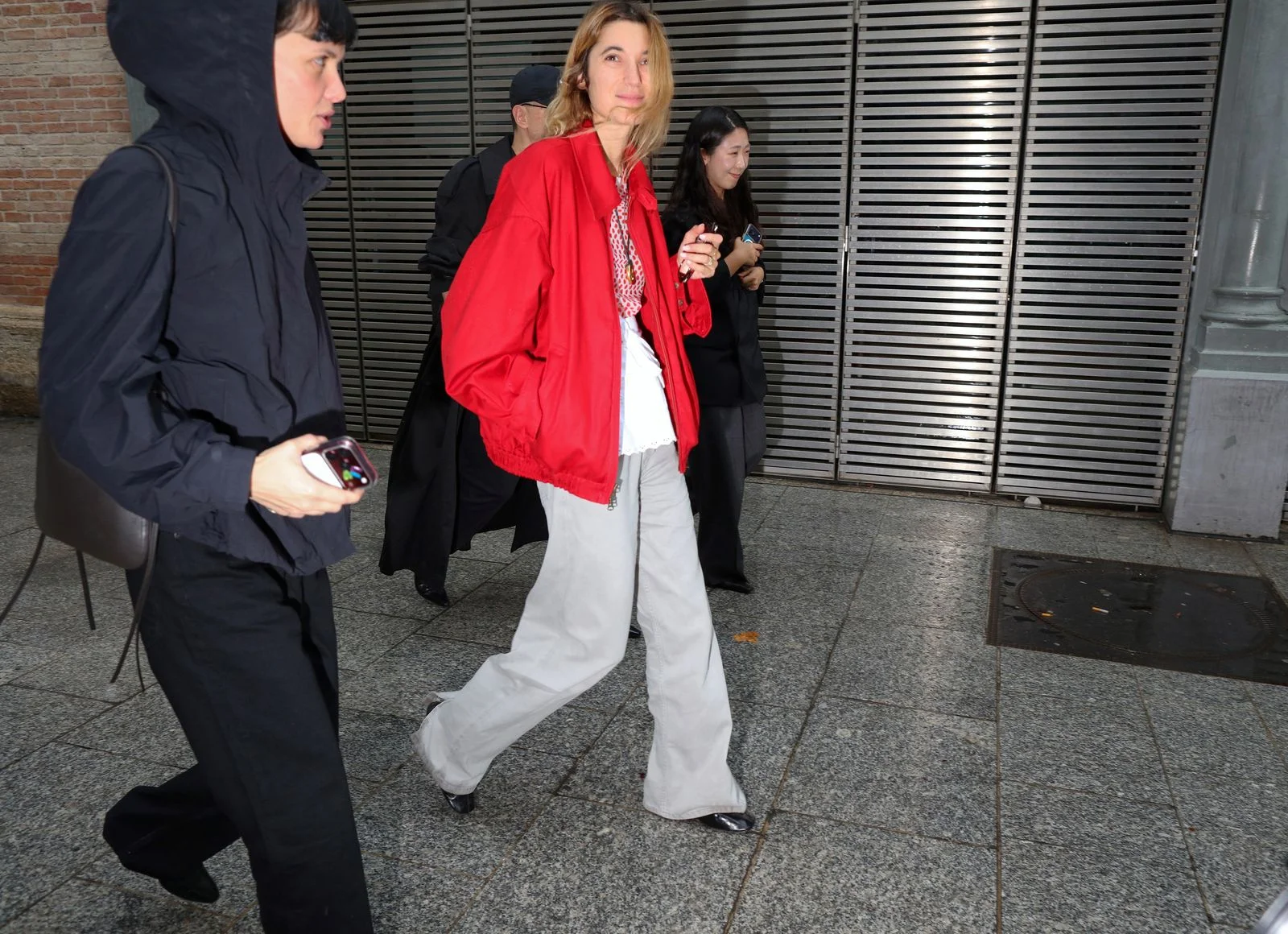 Image may contain Clothing Coat Jacket Blazer Pants Adult Person Walking Footwear Shoe Blouse and Formal Wear