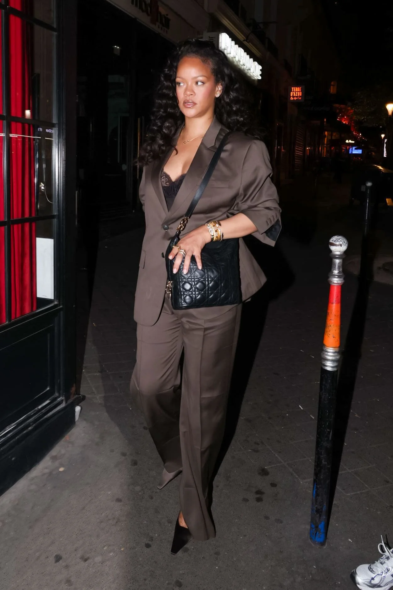 Image may contain Rihanna Adult Person Accessories Bag Handbag Black Hair Hair Curly Hair Standing and Clothing