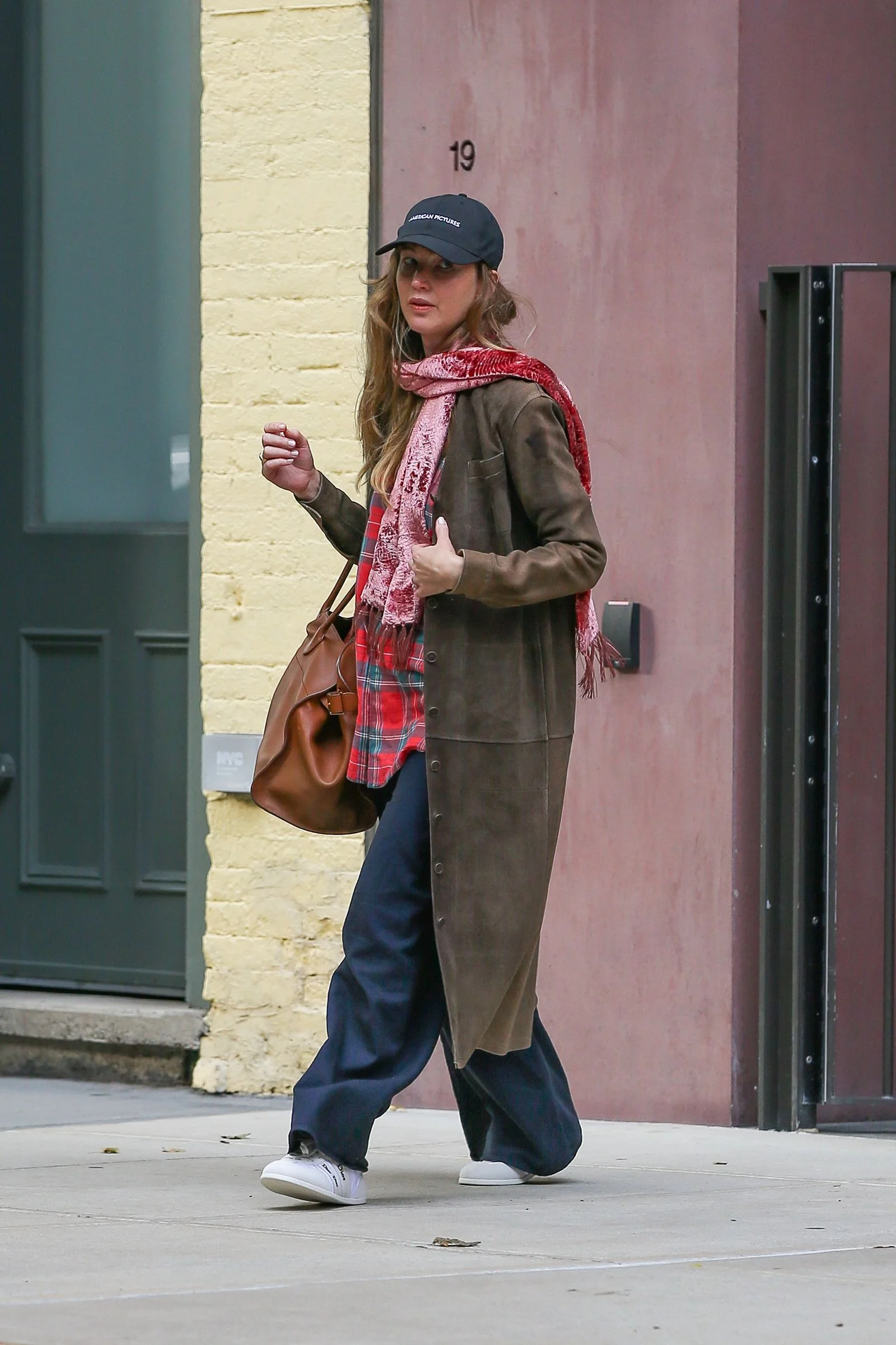 Image may contain Jennifer Lawrence Accessories Bag Handbag Clothing Pants Pedestrian Person Coat Hat and Head
