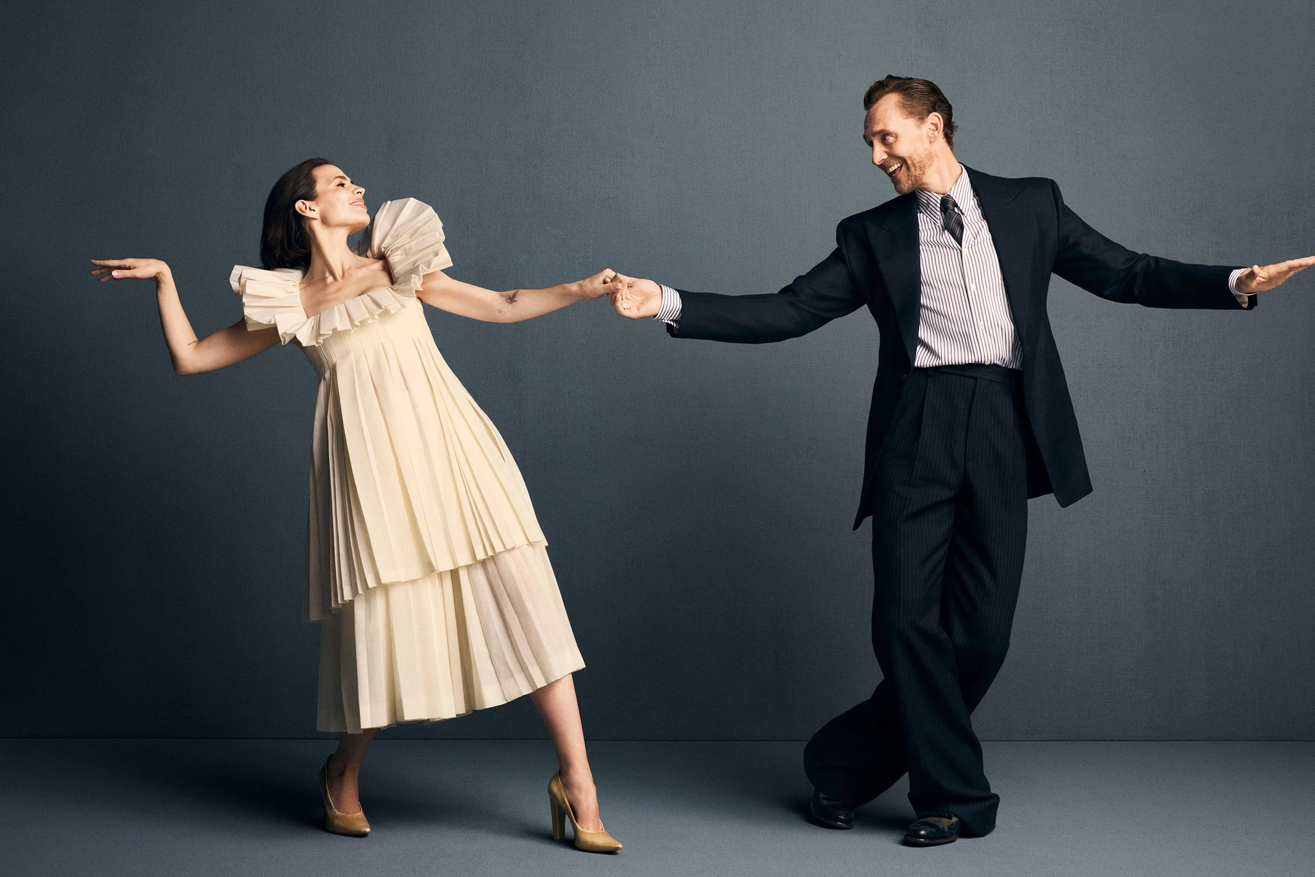 Image may contain Tom Hiddleston Hayley Atwell Adult Person Clothing Formal Wear Suit Body Part Hand and Dress