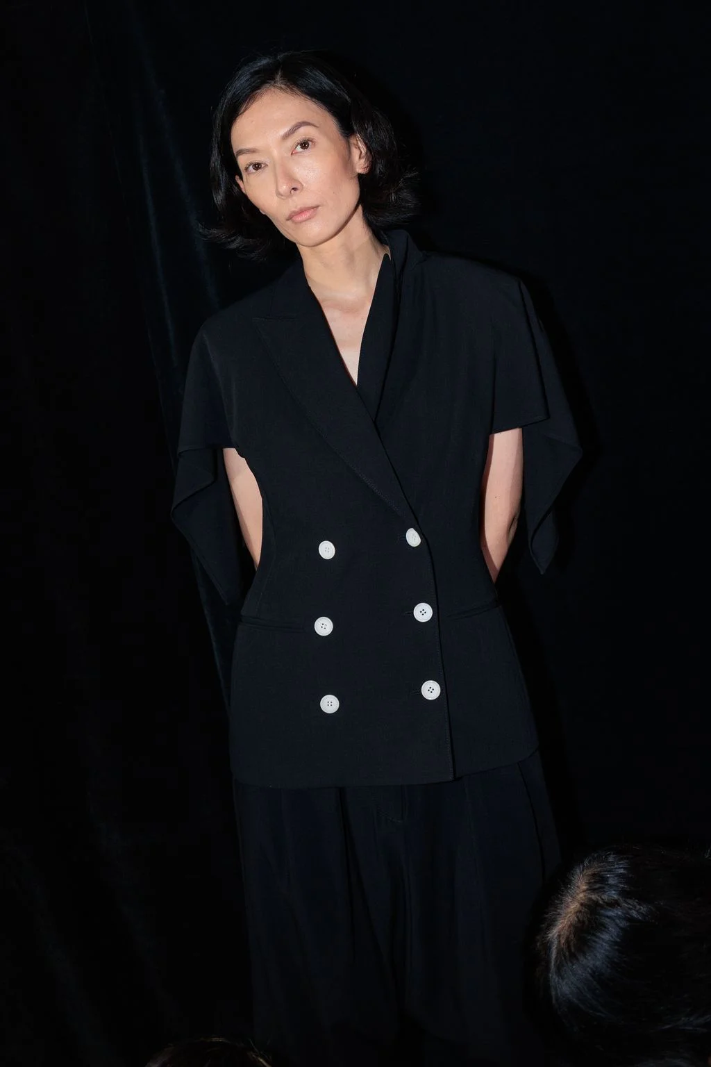 Image may contain Black Hair Hair Person Face Head Photography Portrait Clothing Coat Sleeve and Formal Wear