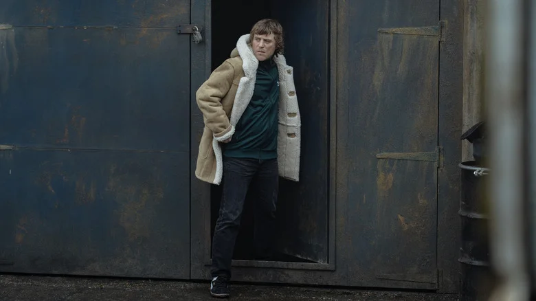 Johnny Flynn's Frankie Cooper steps out of a door in MobLand