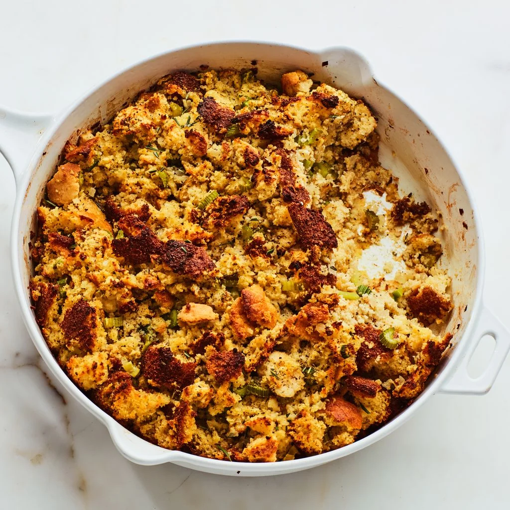 Cornbread and biscuit stuffing with sage in a white skillet.