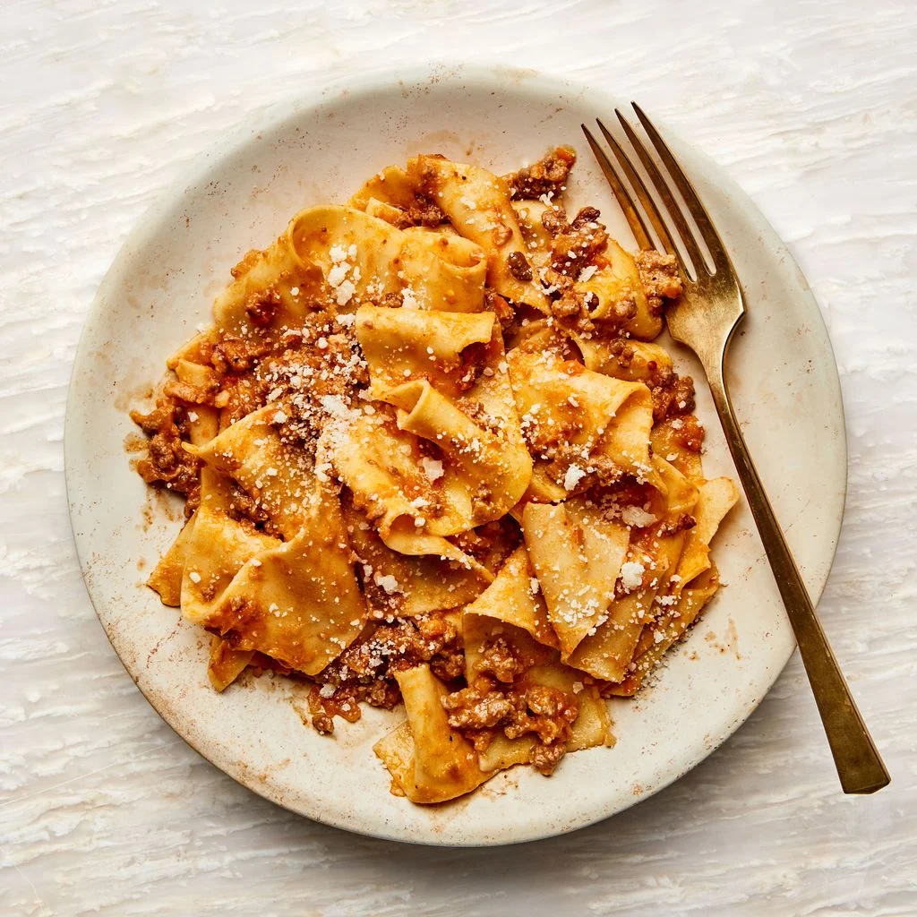 A shallow bowl filled with pappardelle Bolognese.