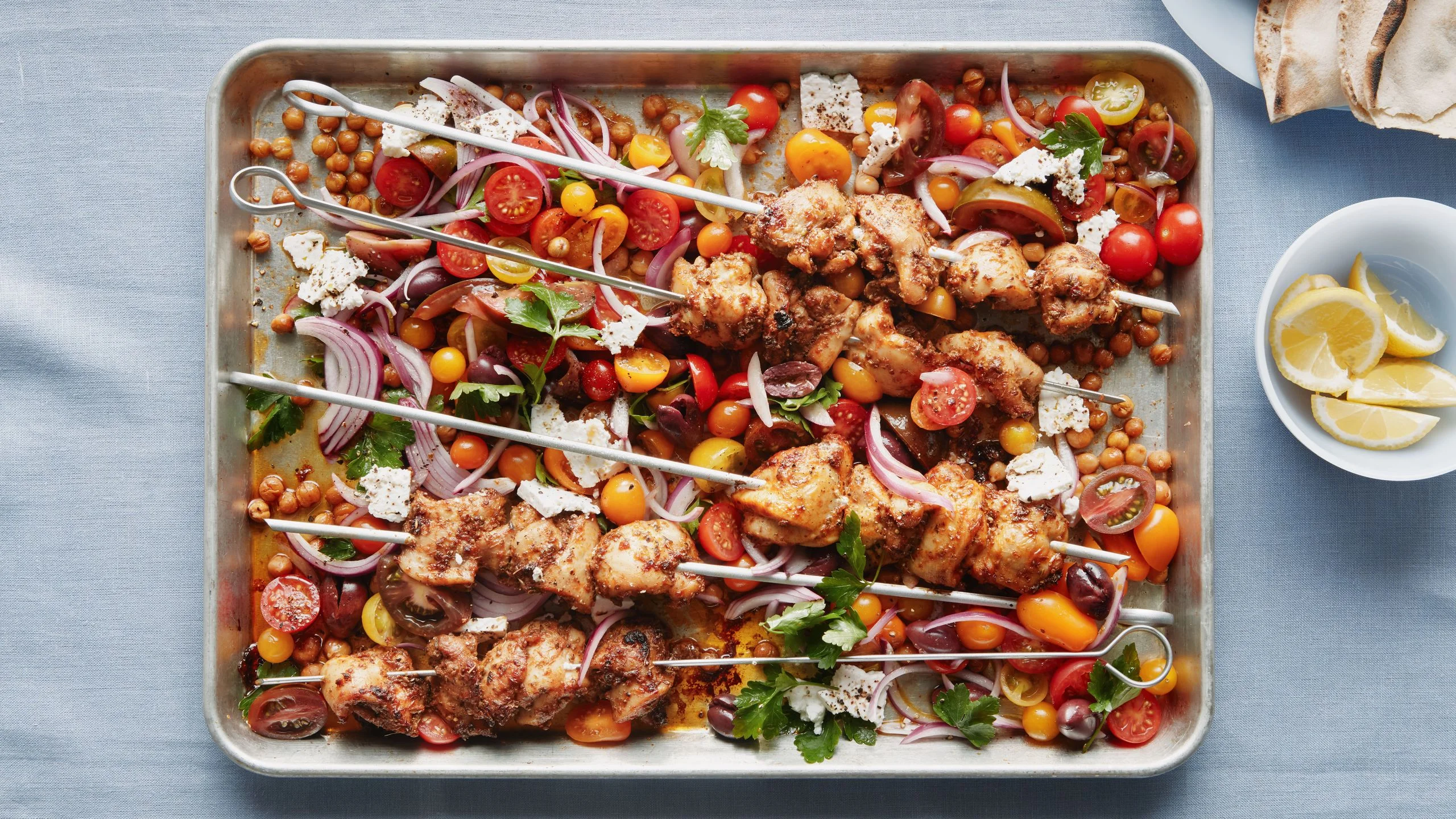 Boneless skinless chicken thighs tossed in oregano cumin sugar black pepper and salt and roasted on skewers on a sheet...